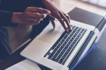 High angle shot of a person using a laptop while working home