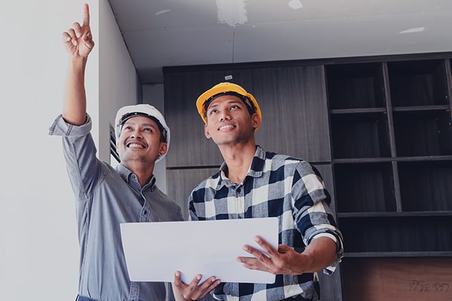A project manager and construction worker reviewing progress on a commercial building interior