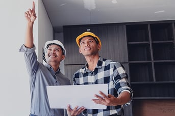 A project manager and construction worker reviewing progress on a commercial building interior