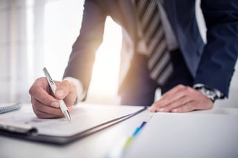 Close up of a businessman in a suit reviewing a document