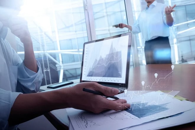 Professional analyzing data on laptop with digital chart overlay visualization