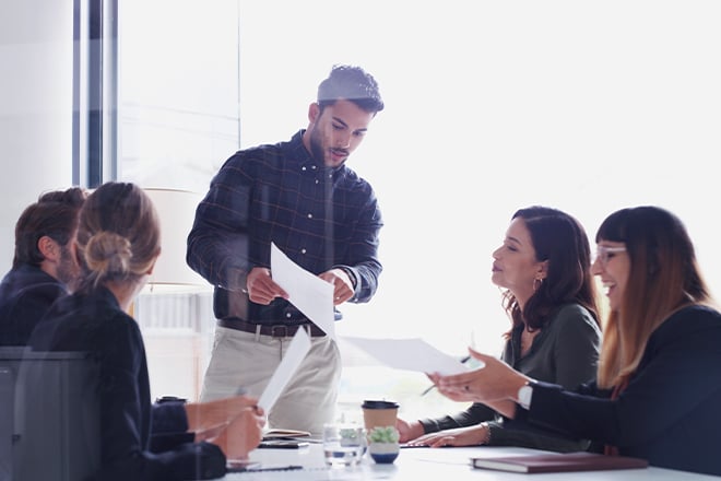 Corporate team in a conference room looking at vendor information together.