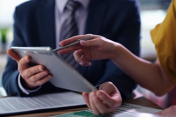 Two business partners are discussing information on tablet