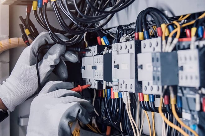 Electrician engineer tests electrical installations and wires on relay protection system.