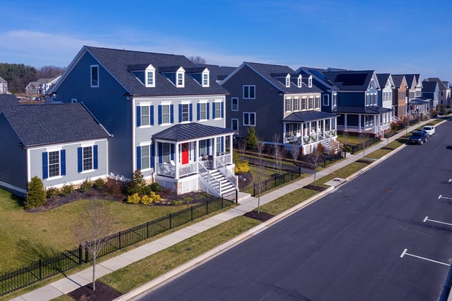 Aerial view of a neighborhood street lined with typical American colonial homes.