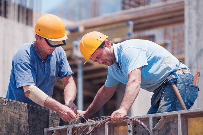 Construction workers working on cement formwork frames