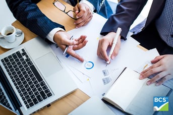 business partners looking down at papers
