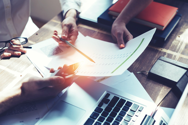 Overhead closeup of a team of employees reviewing documents