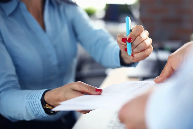 Woman with pen explaining document details to client