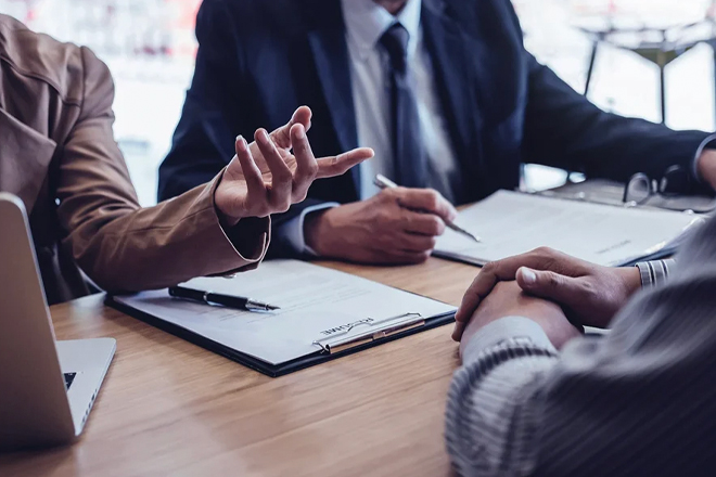 Business meeting with professionals gesturing in discussion over documents