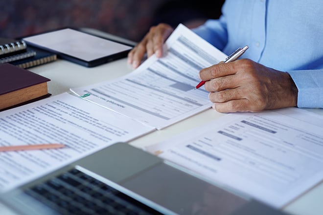 Close up shot of a businessman reviewing documents at his desk