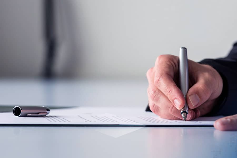 Wide panorama view of businessman hand signing insurance document