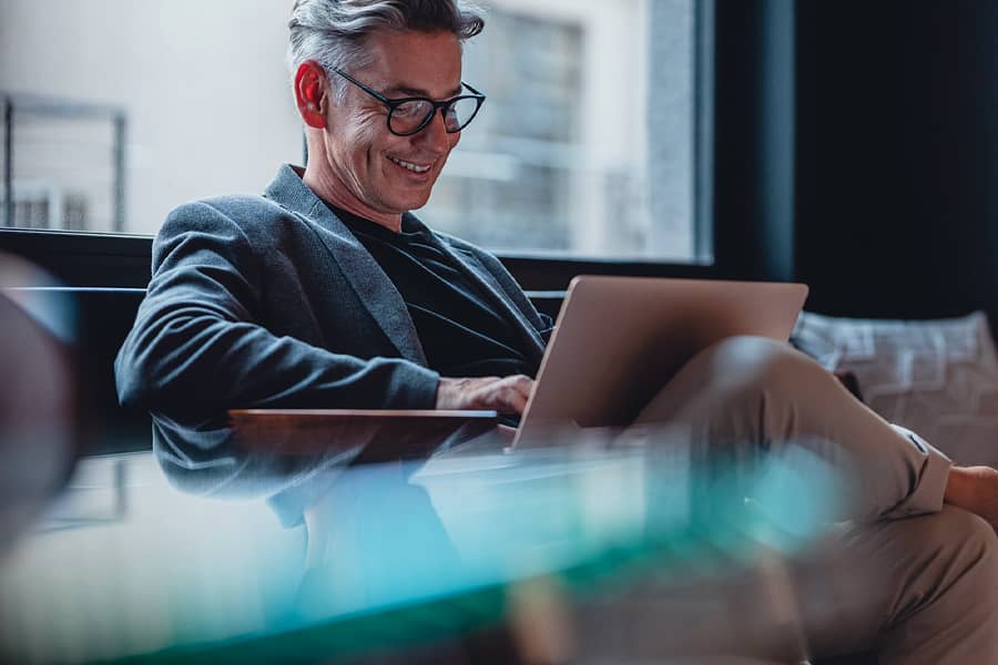 Man working on laptop in office lobby