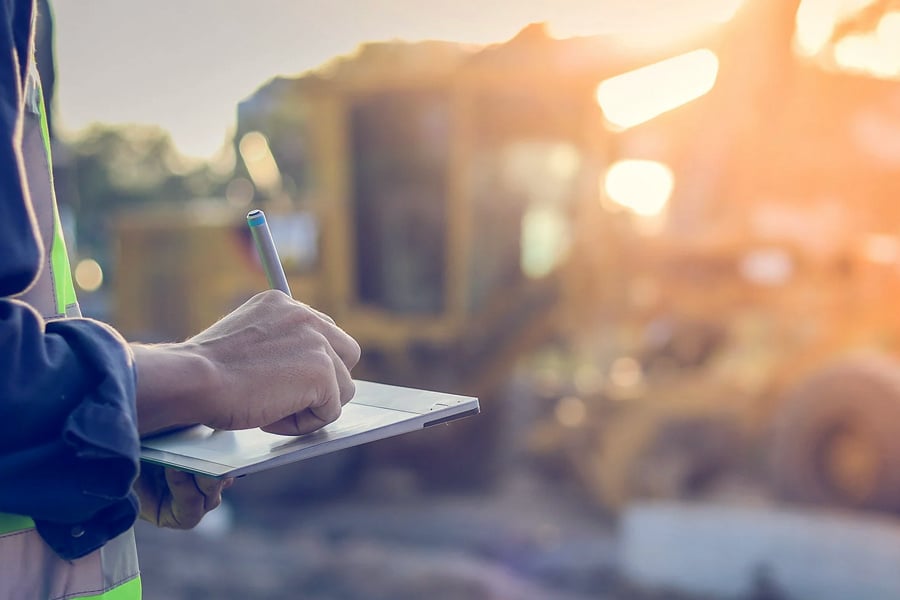 engineer with hardhat using tablet pc computer inspecting and working at construction site