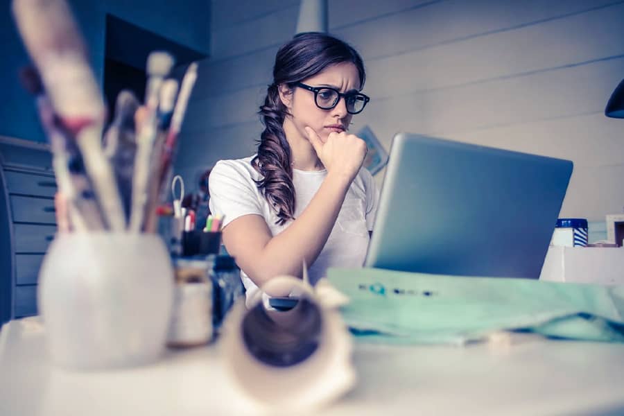 woman frowning at laptop on desk