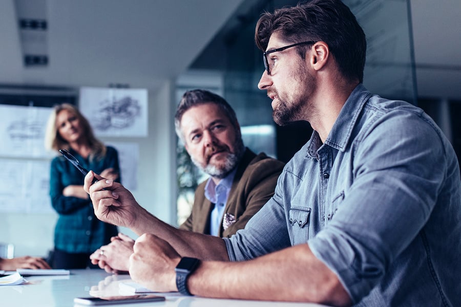 man talking at meeting while team listens