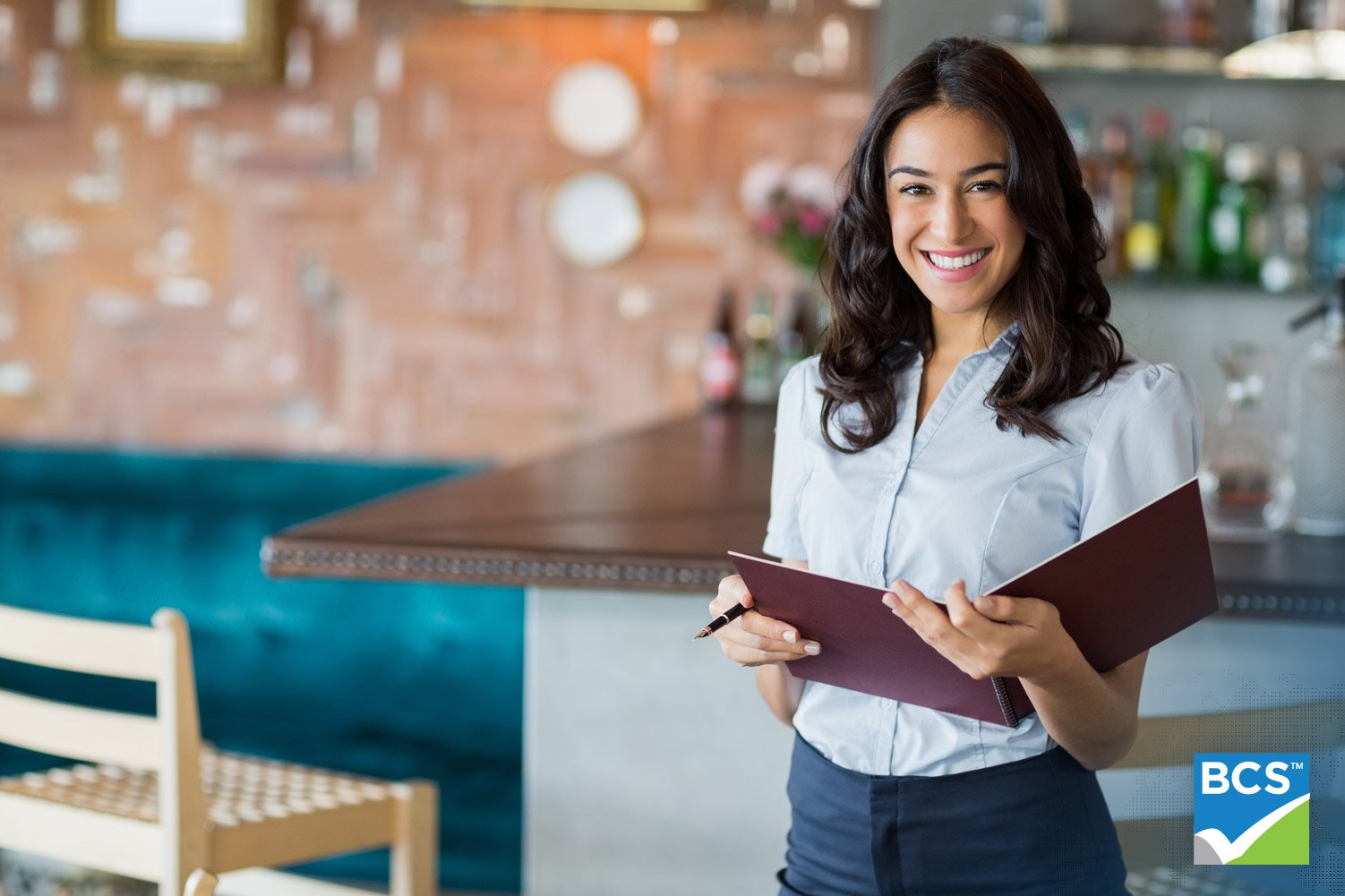 Smiling mixed race waitress holding a file