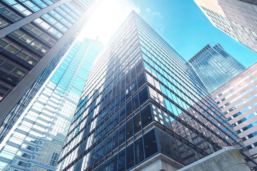 A view looking up at large real estate buildings in a city center.