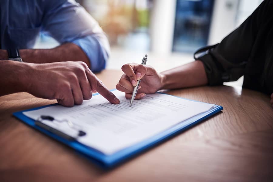Closeup of two people reviewing insurance documents.