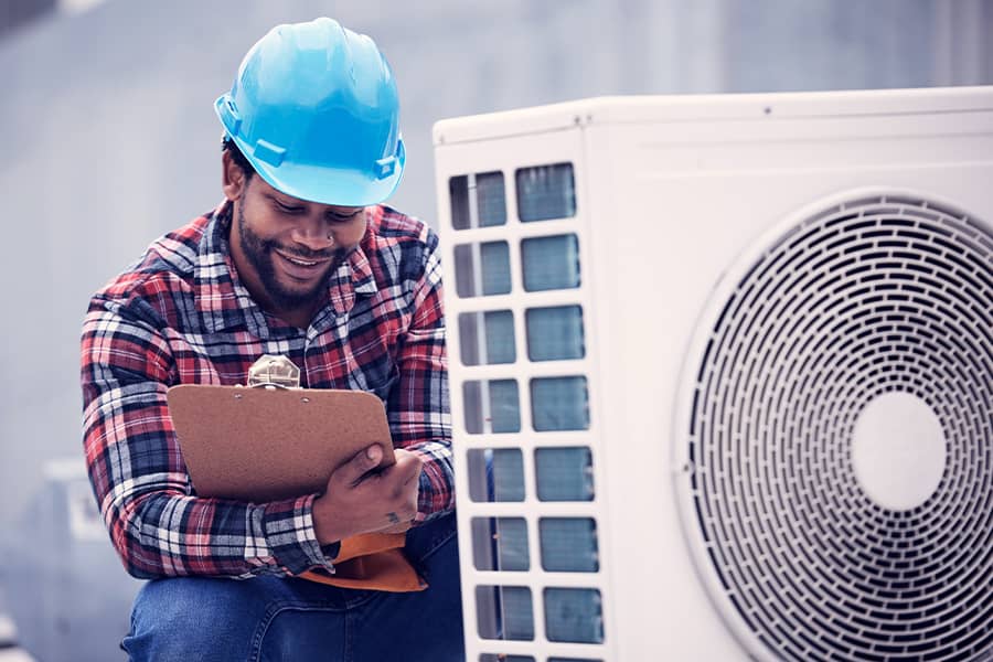 A contractor inspecting an air conditioning unit.