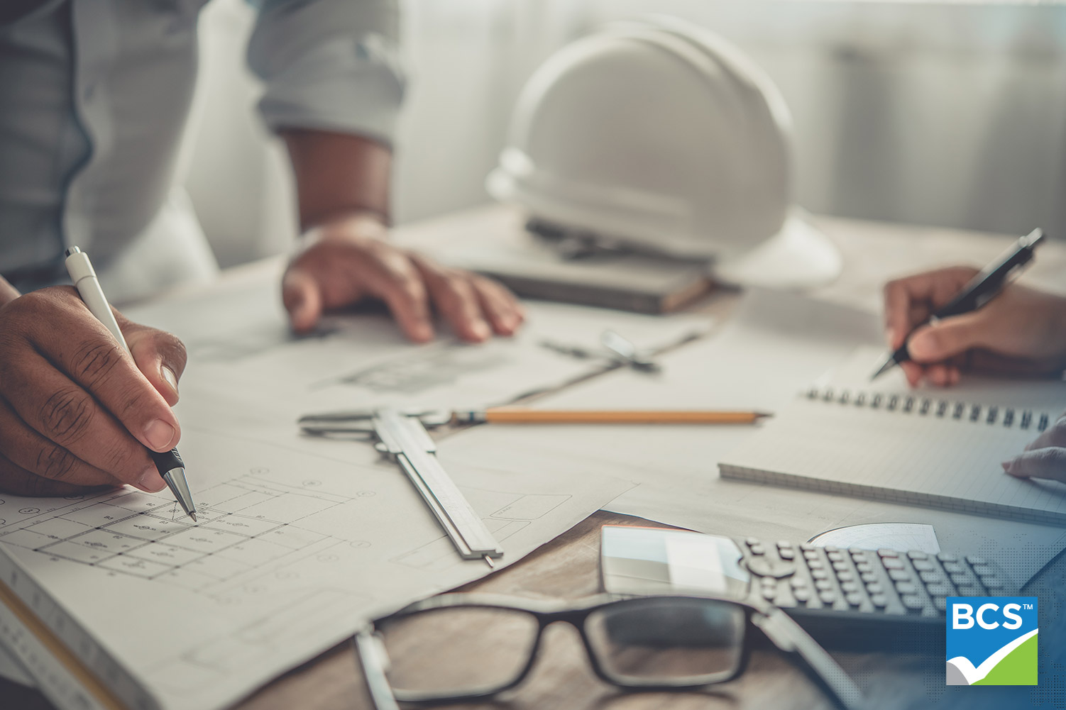 close up of employees working on construction blueprints