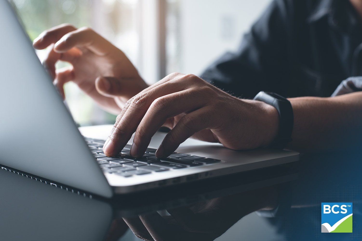 man typing on laptop