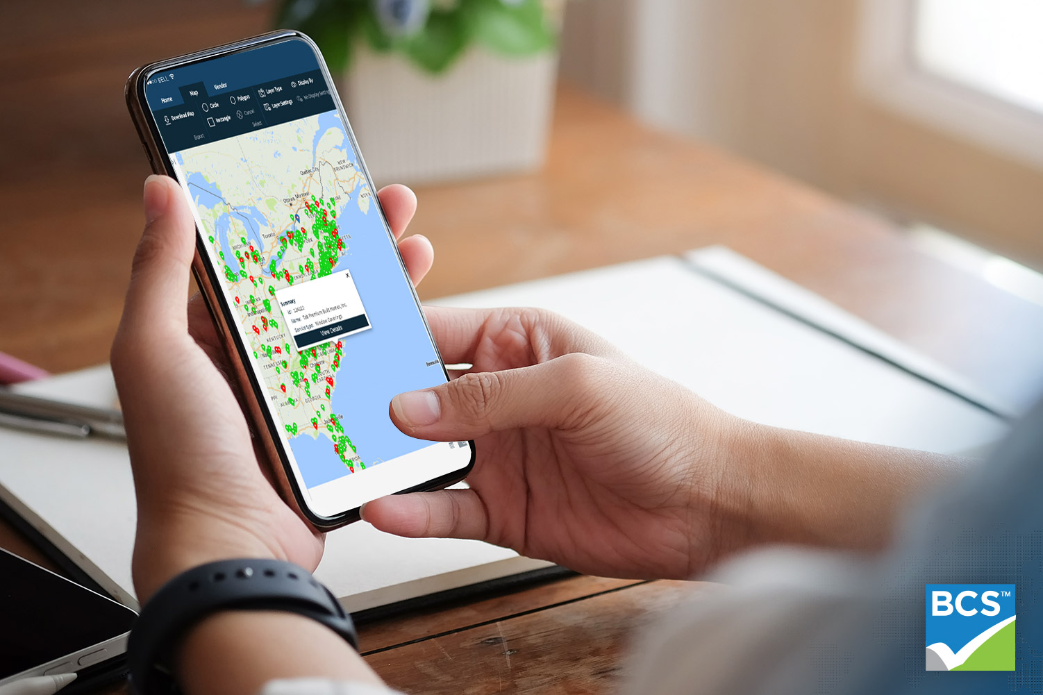 person using bcs app on phone at their desk