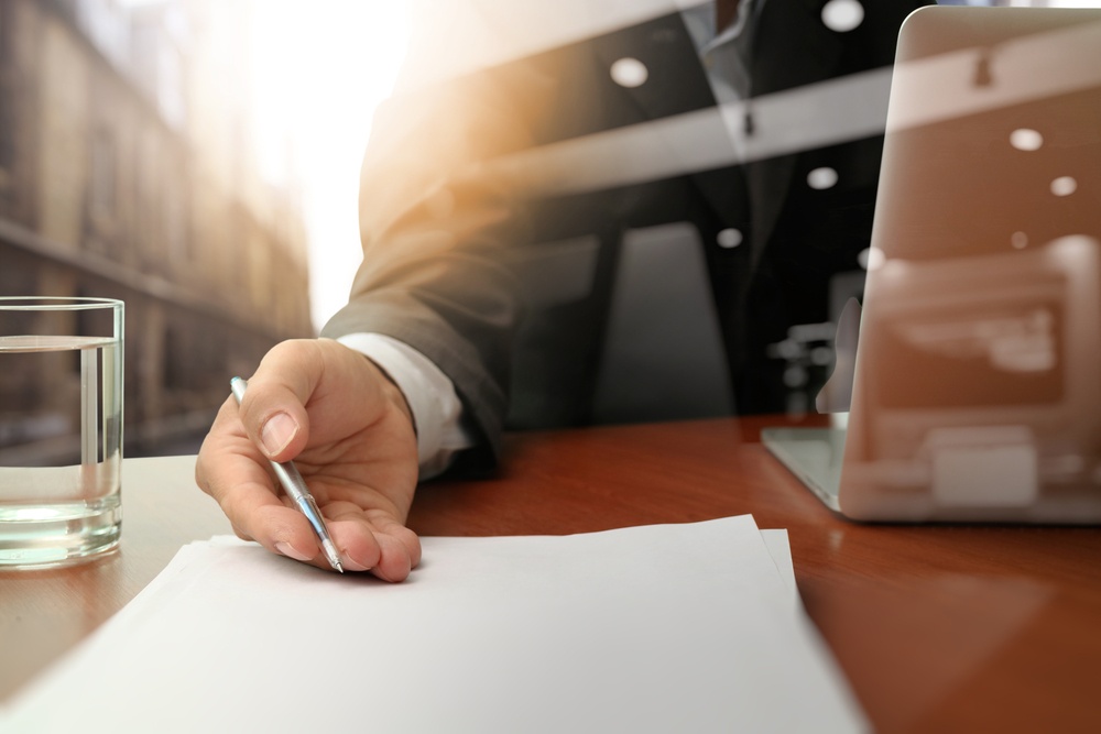 double exposure of businessman handing over a contract on wooden desk