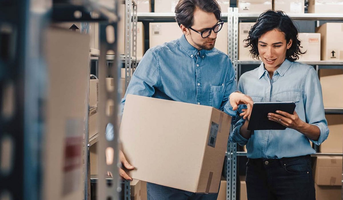 man-and-woman-looking-at-tablet-in-warehouse-setting